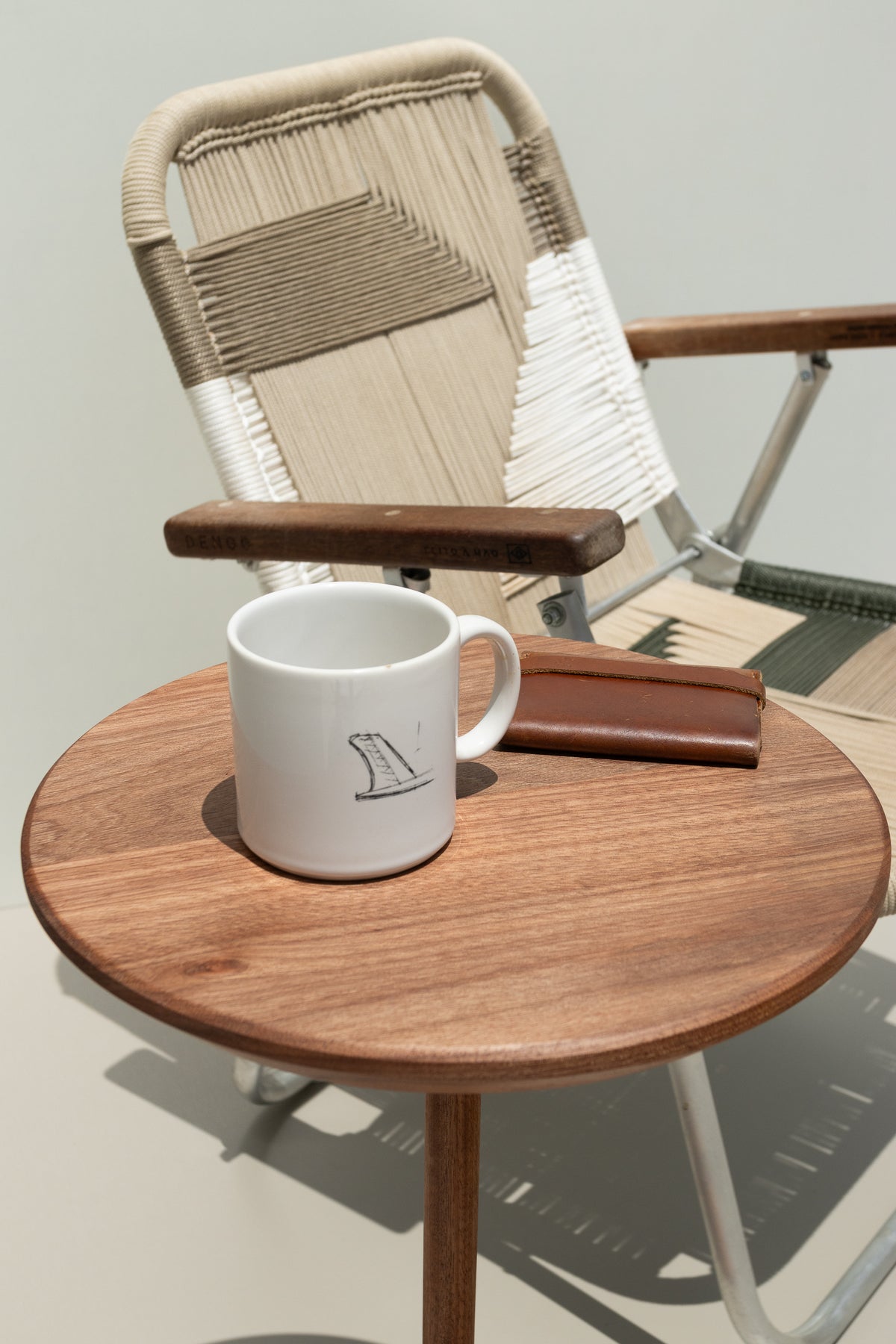 Mesa Serena com xícara, em composição com cadeira trançada.
