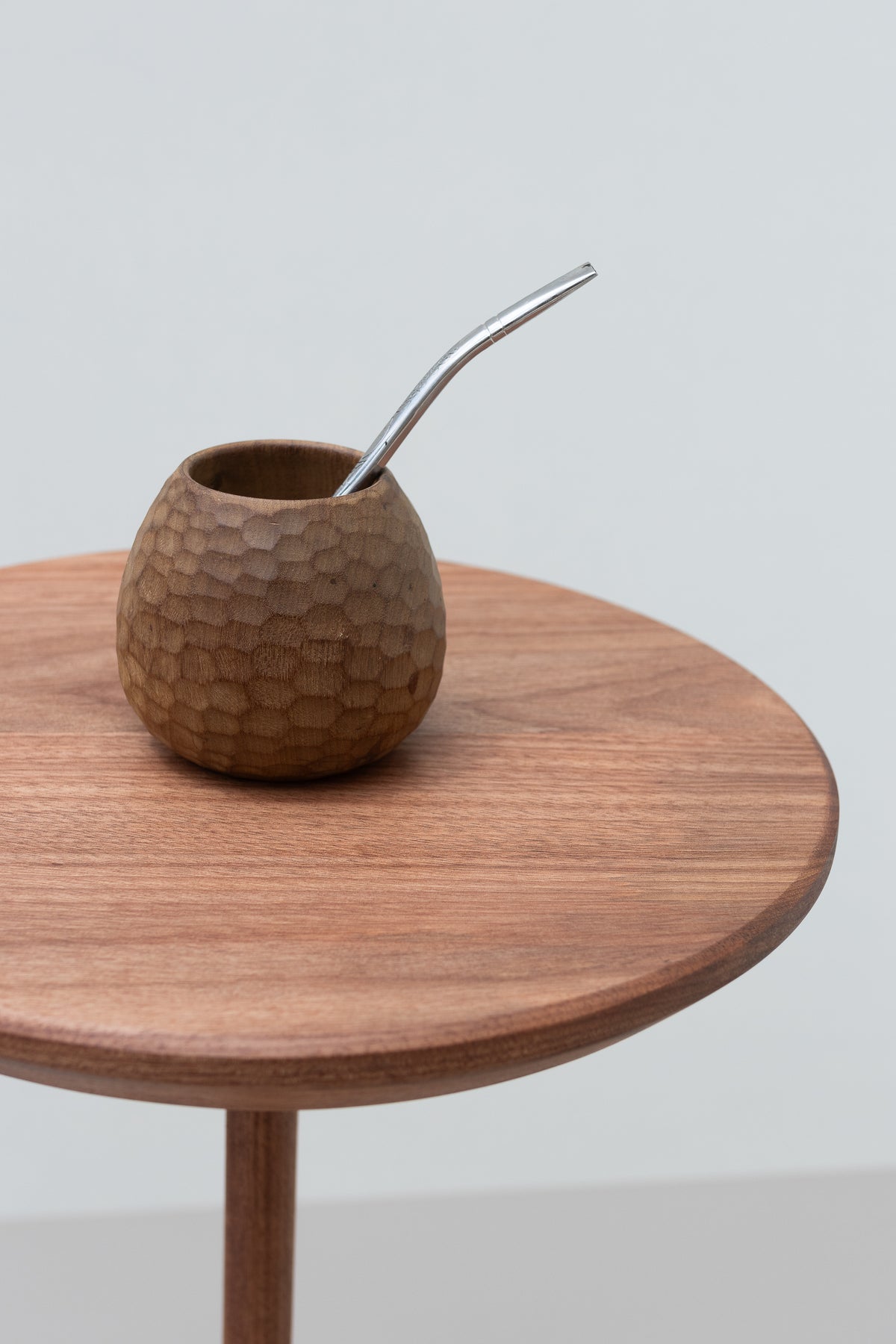 Detalhe dos veios e da borda do tampo da mesa Serena, com cuia de chimarrão.