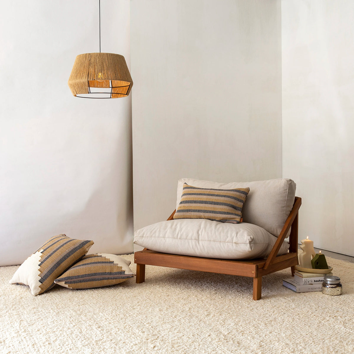 Poltrona Amyr com futons e almofadas ao lado de luminária