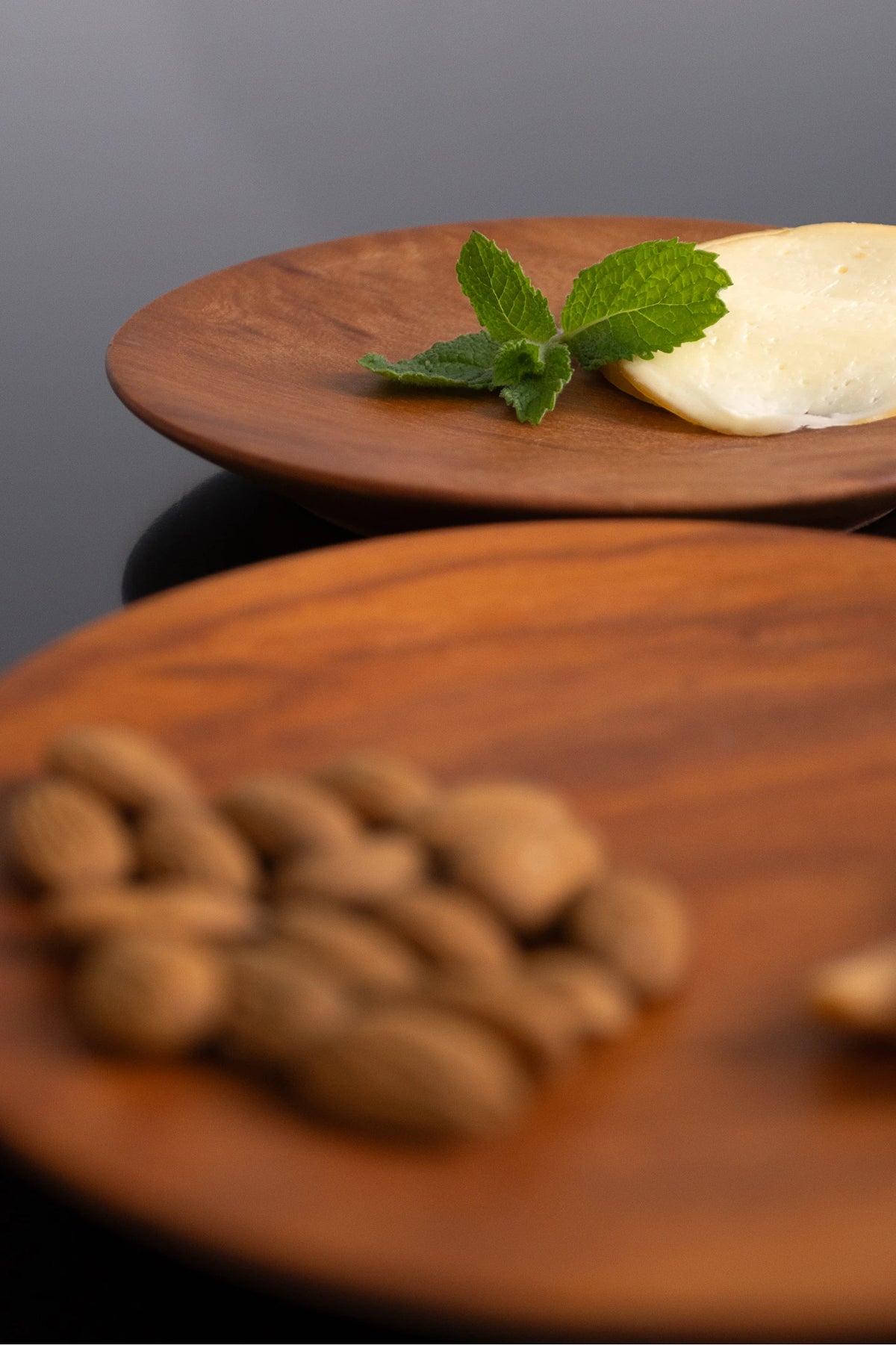Pratos Ligno Duo em diferentes planos com queijo e amêndoas